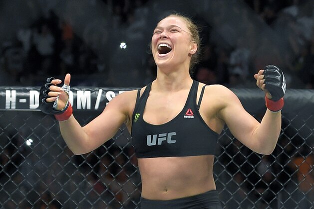FILE - In this Feb. 28, 2015 file photo, Ronda Rousey, with Reebok insignia on her uniform, celebrates after defeating Cat Zingano in a UFC 184 mixed martial arts bantamweight title bout in Los Angeles. UFC fighters will be paid for wearing Reebok gear based on their tenure in the octagon under the mixed martial arts promotion’s new sponsorship deal. The UFC on Wednesday, May 6, 2015, announced the change in its pay structure for its deal with Reebok, which signed on late last year to outfit every fighter. (AP Photo/Mark J. Terrill, File)