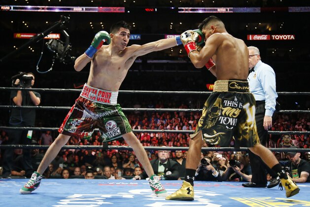 FILE - In this Aug. 29, 2015, file photo, Leo Santa Cruz, left, lands a punch against Abner Mares during the first round of their featherweight boxing bout, in Los Angeles. Santa Cruz won by decision. Nearly three years after Santa Cruz beat Mares by majority decision to win the WBA featherweight title, the two LA-area veterans are doing it again Saturday, June 9, 2018, at Staples Center. (AP Photo/Danny Moloshok,File)