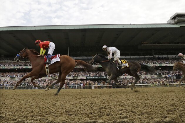 Justify, left, with jockey Mike Smith up, crosses the finish line to win the 150th running of the Belmont Stakes horse race and the Triple Crown, Saturday, June 9, 2018, in Elmont, N.Y. Gronkowski (6), with Jose Ortiz up, was second. (AP Photo/Julio Cortez)