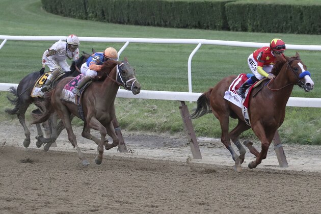 Justify, right, ridden by Mike Smith, leads the field around the far turn during the Belmont Stakes horse race, Saturday, June 9, 2018, at Belmont Park in Elmont, N.Y. Justify won the race, to claim horse racing's Triple Crown (AP Photo/Mary Altaffer)