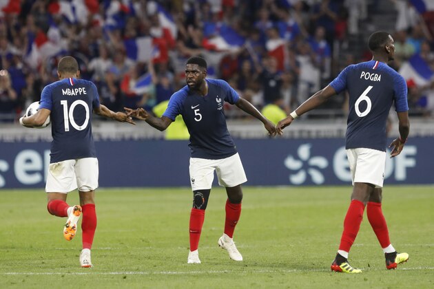 France's Kylian Mbappe, left, celebrates with teammates France's Samuel Umtiti, centre, and Paul Pogba after scoring his side's first goal during a friendly soccer match between France and USA at the Groupama stadium in Decines, near Lyon, central France, Saturday, June 9, 2018. (AP Photo/Laurent Cipriani)