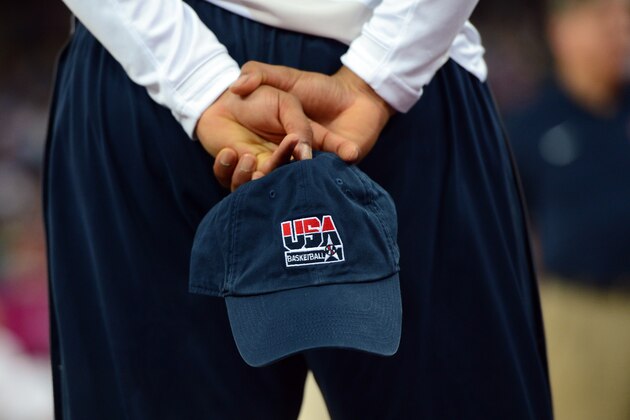A man holds a cap bearing the logo 'USA basketball' during the London 2012 Olympic Games women's gold medal basketball game between the USA and France at the North Greenwich Arena in London on August 11, 2012. AFP PHOTO /MARK RALSTON        (Photo credit should read MARK RALSTON/AFP/GettyImages)