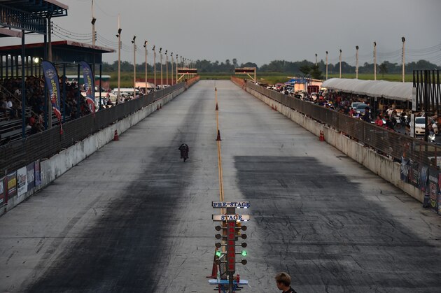 This photo taken on August 13, 2017 shows a drag racer speeding down the racetrack during an 'NGO Street Drag Bike Party', a legal racing event, in the central Thai province of Pathum Thani.
The streets of Bangkok are frequently clogged with thousands of motorbikes, and many Thais learn to ride the vehicles from a young age. But for those wanting to take their riding to the next level, a stadium on the outskirts of the Thai capital hosts monthly drag races. / AFP PHOTO / LILLIAN SUWANRUMPHA        (Photo credit should read LILLIAN SUWANRUMPHA/AFP/Getty Images)