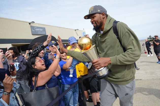 OAKLAND, CA - JUNE 11: Kevin Durant #35 of the Golden State Warriors exits the plane with the Bill Russell Finals MVP Trophy and shakes fans hands at Oakland International Airport on June 11, 2018 in Oakland, California. NOTE TO USER: User expressly acknowledges and agrees that, by downloading and/or using this photograph, user is consenting to the terms and conditions of the Getty Images License Agreement. Mandatory Copyright Notice: Copyright 2018 NBAE (Photo by Noah Graham/NBAE via Getty Images)