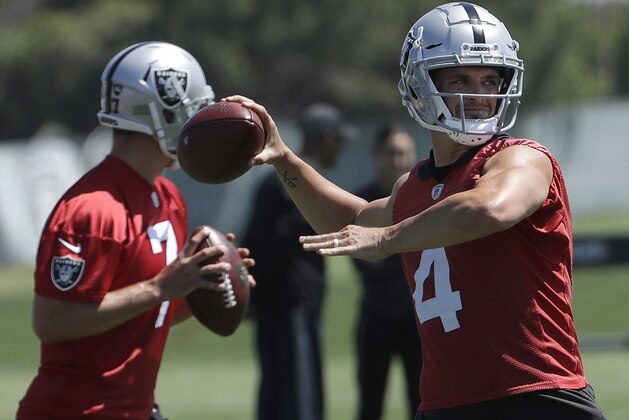 Oakland Raiders quarterbacks Derek Carr (4) and Christian Hackenberg (7) throw passes during practice at the team's NFL football training facility in Alameda, Calif., Tuesday, May 29, 2018. (AP Photo/Jeff Chiu)