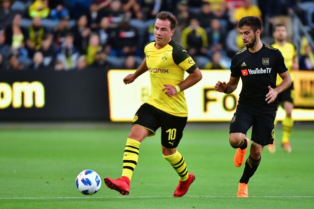 Mario Gotze of Borussia Dortmund (L) passes the ball under pressure from Diego Rossi of LAFC (Los Angeles Football Club) during their international soccer friendly in Los Angeles, California on May 22, 2018. (Photo by Frederic J. BROWN / AFP)        (Photo credit should read FREDERIC J. BROWN/AFP/Getty Images)