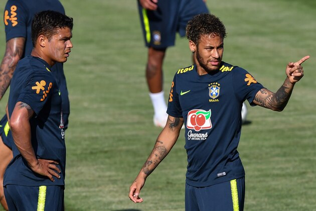 Brazil's defender Thiago Silva (L) and Brazil's forward Neymar (R) speak together as they take part in a training session of Brazil national football team at Yug Sport Stadium, in Sochi, on June 14, 2018, ahead of the Russia 2018 World Cup football tournament. (Photo by NELSON ALMEIDA / AFP)        (Photo credit should read NELSON ALMEIDA/AFP/Getty Images)