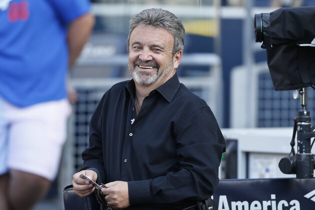 Los Angeles Dodgers general manager Ned Colletti finds something to laugh about while watching his team during warmups prior to a baseball game against the San Diego Padres Friday, June 20, 2014, in San Diego. (AP Photo/Lenny Ignelzi)
