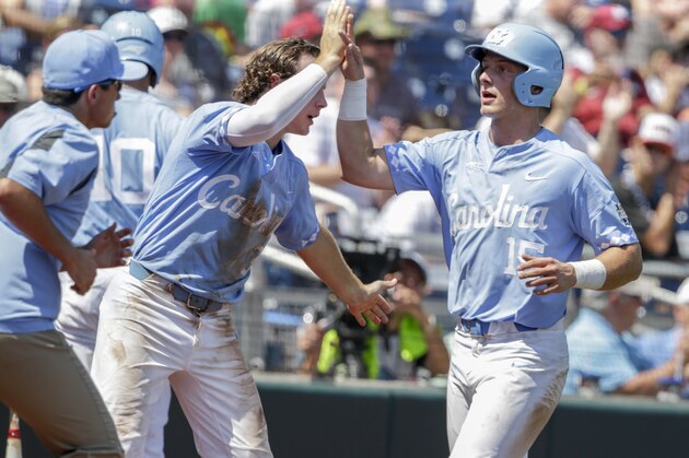 North Carolina's Michael Busch (15) is greeted by Brandon Riley after scoring on a fly ball by Riley in the third inning of an NCAA College World Series baseball game against Oregon State in Omaha, Neb., Saturday, June 16, 2018. (AP Photo/Nati Harnik)