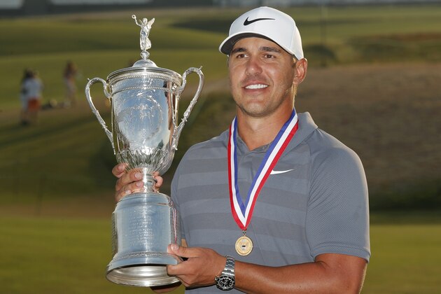 Brooks Koepka holds up the Golf Champion Trophy after winning the U.S. Open Golf Championship, Sunday, June 17, 2018, in Southampton, N.Y. (AP Photo/Carolyn Kaster)
