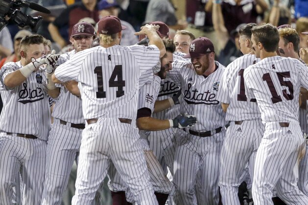 Mississippi State players mob Luke Alexander, center, who hit a single that drove in Hunter Stovall with the winning run against Washington in the ninth inning of an NCAA College World Series baseball game in Omaha, Neb., Saturday, June 16, 2018. Mississippi State won 1-0. (AP Photo/Nati Harnik)