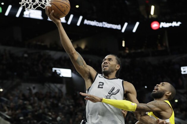 San Antonio Spurs forward Kawhi Leonard (2) scores past Denver Nuggets guard Will Barton (5) during the second half of an NBA basketball game Saturday, Jan. 13, 2018, in San Antonio. San Antonio won 112-80. (AP Photo/Eric Gay)