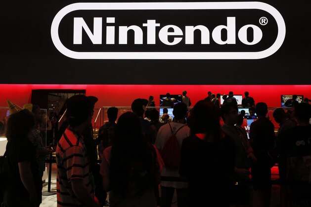 In this Thursday, June 14, 2018, people play Nintendo games at the 24th Electronic Expo, or E3 2018 in Los Angeles. (AP Photo/Damian Dovarganes)
