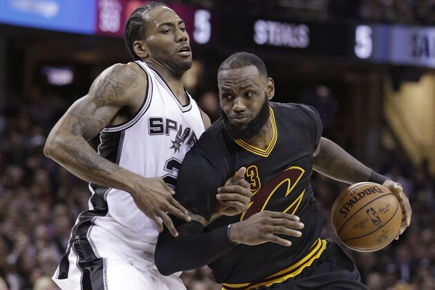 Cleveland Cavaliers' LeBron James, right, drives against San Antonio Spurs' Kawhi Leonard during the second half of an NBA basketball game, Saturday, Jan. 21, 2017, in Cleveland. The Spurs won 118-115 in overtime. (AP Photo/Tony Dejak)