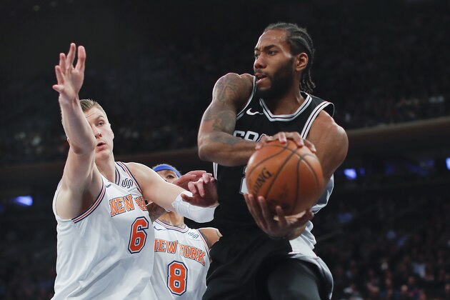 San Antonio Spurs forward Kawhi Leonard (2) passes the ball against New York Knicks forward Kristaps Porzingis (6) during the fourth quarter of an NBA basketball game, Tuesday, Jan. 2, 2018, in New York. The Spurs won 100-91. (AP Photo/Julie Jacobson)