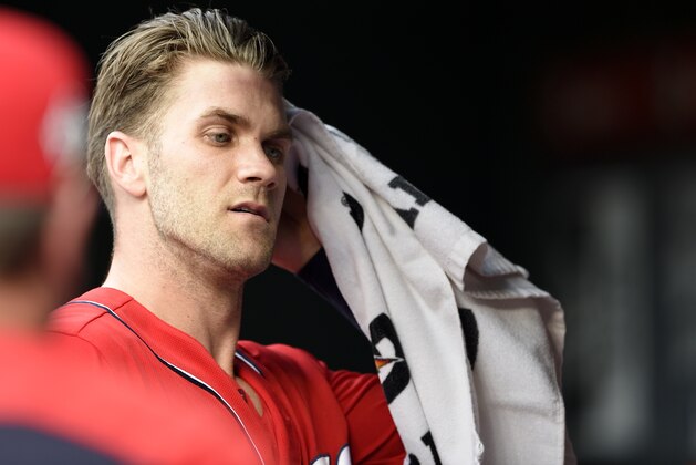 Washington Nationals' Bryce Harper towels off in the dugout before the continuation of a suspended baseball game against the New York Yankees, Monday, June 18, 2018, in Washington. This game is a continuation of a suspended game from May 15. (AP Photo/Nick Wass)