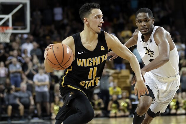 Wichita State's Landry Shamet (11) drives past Central Florida's A.J. Davis, right, during the second half of an NCAA college basketball game, Thursday, March 1, 2018, in Orlando, Fla. (AP Photo/John Raoux)