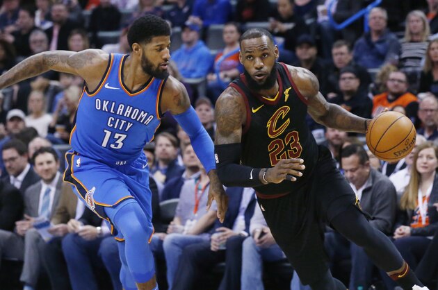 Cleveland Cavaliers forward LeBron James (23) drives past Oklahoma City Thunder forward Paul George (13) during the first half of an NBA basketball game in Oklahoma City, Tuesday, Feb. 13, 2018. (AP Photo/Sue Ogrocki)