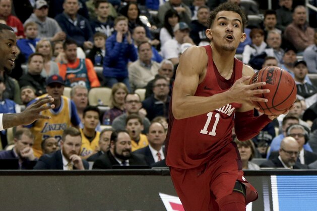 FILE - In this March 15, 2018, file photo, Oklahoma's Trae Young drives to the hoop during overtime of an NCAA men's college basketball tournament first-round game against Rhode Island,in Pittsburgh. Young is a member of the Associated Press NCAA college basketball All-America first team, announced Tuesday, March 27, 2018.(AP Photo/Keith Srakocic, File)