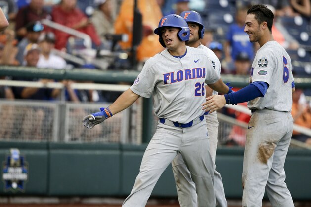 Florida center fielder Nick Horvath (26) celebrates his solo home run against Texas with Jonathan India (6) and Nelson Maldonado, rear, in the eighth inning of an NCAA College World Series baseball elimination game in Omaha, Neb., Tuesday, June 19, 2018. Florida won 6-1. (AP Photo/Nati Harnik)