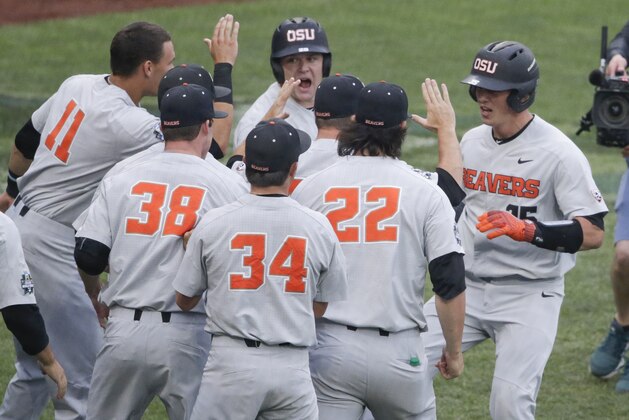 Oregon State's Adley Rutschman, right, is congratulated near the dugout after his solo home run against North Carolina during the first inning of an NCAA College World Series baseball elimination game in Omaha, Neb., Wednesday, June 20, 2018. (AP Photo/Nati Harnik)