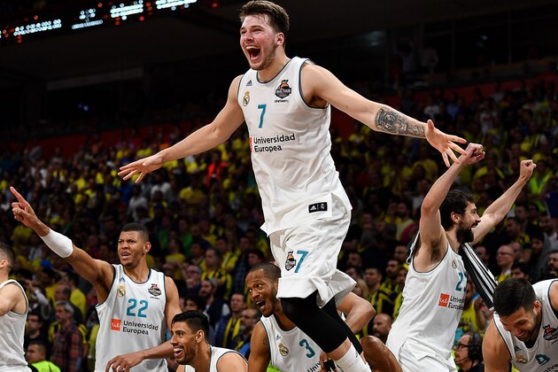 TOPSHOT - Real Madrid's Slovenian Luka Doncic (C-7) jumps over the barrier as the team celebrates their 85-80 win in the Euroleague Final Four finals basketball match between Real Madrid and Fenerbahce Dogus Istanbul at The Stark Arena in Belgrade on May 20, 2018. (Photo by Andrej ISAKOVIC / AFP)        (Photo credit should read ANDREJ ISAKOVIC/AFP/Getty Images)