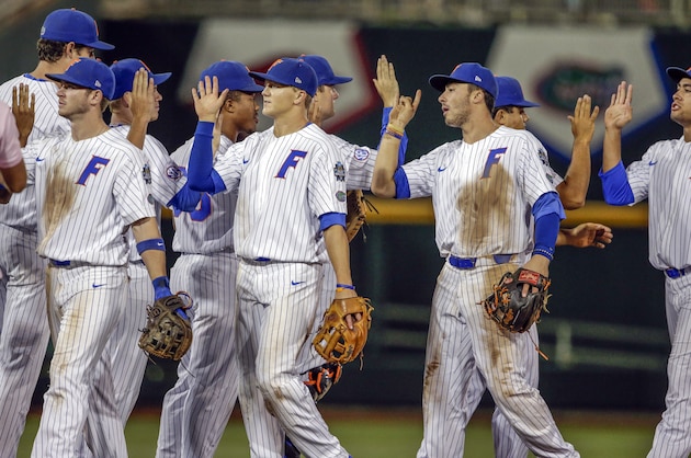 Florida players including Jonathan India, second right, exchange high-fives following an NCAA College World Series baseball elimination game against Texas Tech in Omaha, Neb., Thursday, June 21, 2018. Florida won 9-6. (AP Photo/Nati Harnik)