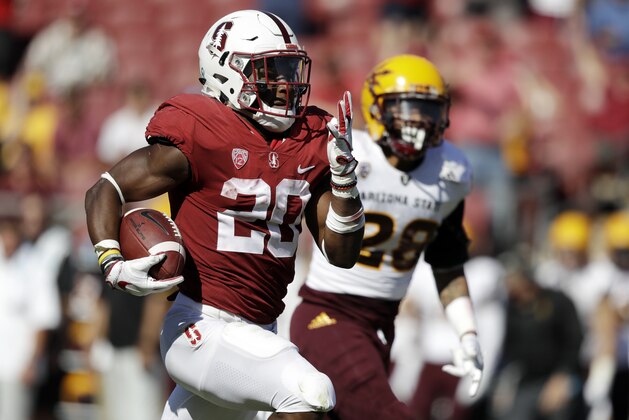 FILE - In this Sept. 30, 2017, file photo, Stanford running back Bryce Love, left, runs for a touchdown past Arizona State defensive back Demonte King (28) during the third quarter of an NCAA college football game in Stanford, Calif. Love established himself as a Heisman candidate early by rushing for 564 yards in back-to-back wins over UCLA and Arizona State. He kept adding to those numbers and leads all Power 5 running backs in yards rushing (1,973) yards per carry (8.3) and 100-yard games (11), and also set an FBS record with 12 runs of at least 50 yards. (AP Photo/Marcio Jose Sanchez, File)