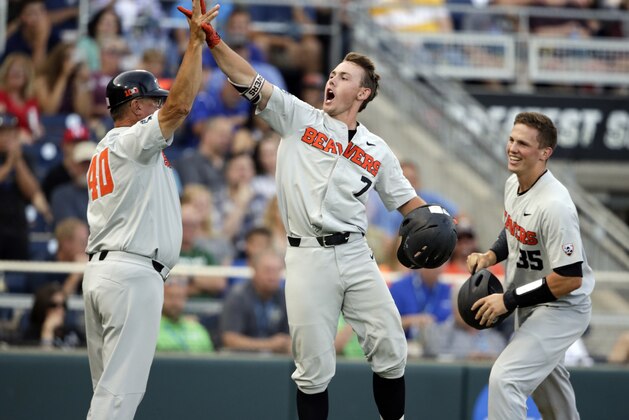 Oregon State's Tyler Malone (7) celebrates with Adley Rutschman (35) and Michael Attalah (40) after hitting a three-run home run against Mississippi State in the third inning of an NCAA College World Series baseball elimination game in Omaha, Neb., Saturday, June 23, 2018. (AP Photo/Nati Harnik)