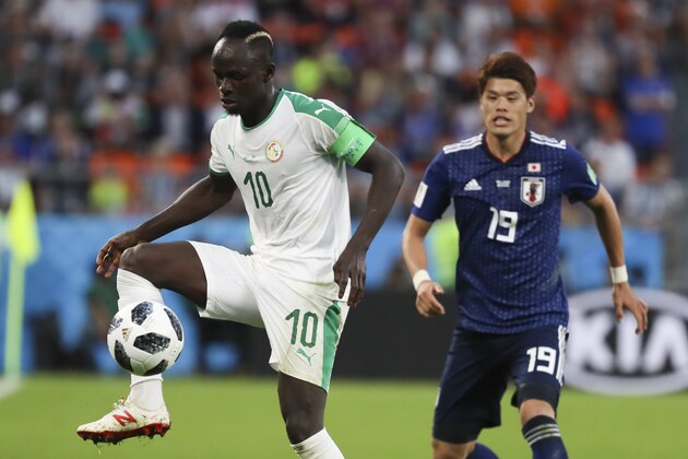 Senegal's Sadio Mane, left, controls the ball ahead of Japan's Hiroki Sakai during the group H match between Japan and Senegal at the 2018 soccer World Cup at the Yekaterinburg Arena in Yekaterinburg , Russia, Sunday, June 24, 2018. (AP Photo/Eugene Hoshiko)