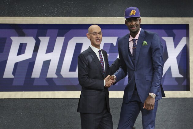 Arizona's Deandre Ayton, right, poses with NBA Commissioner Adam Silver after he was picked first overall by the Phoenix Suns during the NBA basketball draft in New York, Thursday, June 21, 2018. (AP Photo/Kevin Hagen)