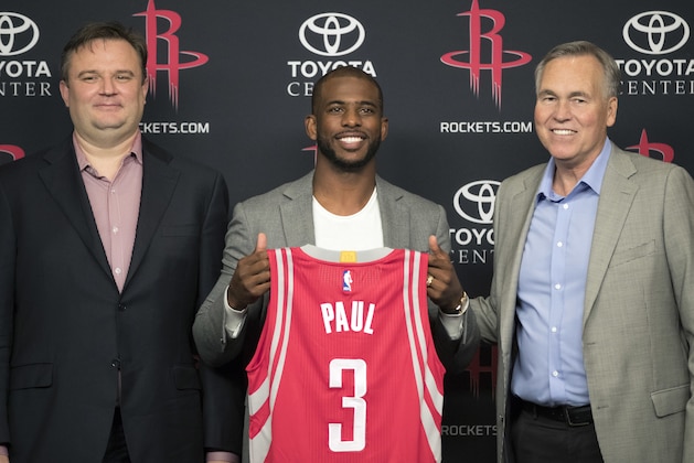 Chris Paul, center, holds his new jersey as he is joined by Houston Rockets general manager Daryl Morey, left, and coach Mike D'Antoni, right, during a news conference Friday, July 14, 2017, in Houston. The nine-time All-Star was traded from the Los Angeles Clippers late last month. (AP Photo/David J. Phillip)