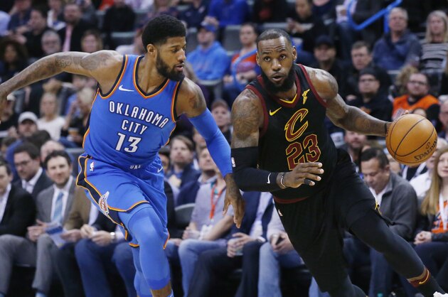 Cleveland Cavaliers forward LeBron James (23) drives past Oklahoma City Thunder forward Paul George (13) during the first half of an NBA basketball game in Oklahoma City, Tuesday, Feb. 13, 2018. (AP Photo/Sue Ogrocki)