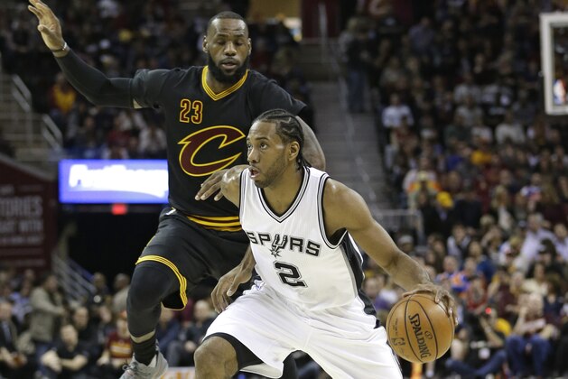 San Antonio Spurs' Kawhi Leonard (2) drives past Cleveland Cavaliers' LeBron James (23) in the first half of an NBA basketball game, Saturday, Jan. 21, 2017, in Cleveland. (AP Photo/Tony Dejak)