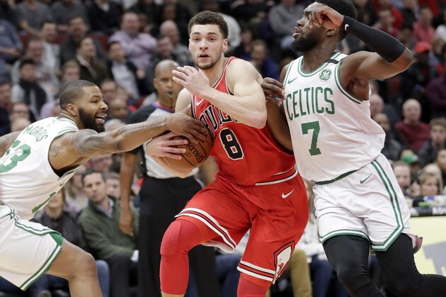 Boston Celtics' Marcus Morris, left, gets his hand on the ball as Chicago Bulls' Zach LaVine (8) drives to the basket as Jaylen Brown (7) also defends during the first half of an NBA basketball game Monday, March 5, 2018, in Chicago. The Bulls won 108-100. (AP Photo/Charles Rex Arbogast)