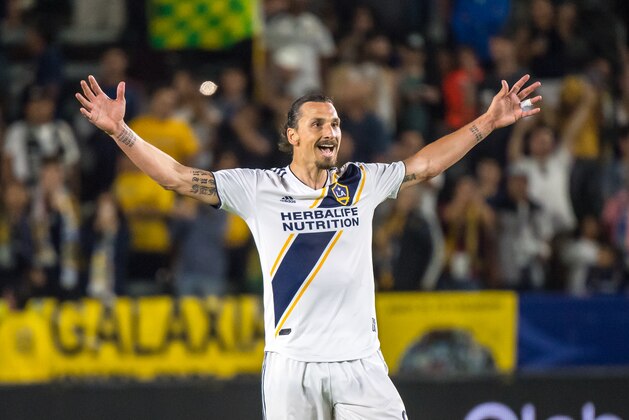 CARSON, CA - JUNE 9: Zlatan Ibrahimovic #9 of Los Angeles Galaxy celebrates his second goal of the game as Justen Glad #15 of Real Salt Lake tries to defend during the Los Angeles Galaxy's MLS match against FC Dallas at the StubHub Center on June 9, 2018 in Carson, California. Los Angeles Galaxy won the match 3-0 (Photo by Shaun Clark/Getty Images)