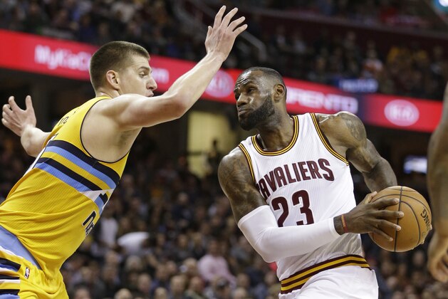 Cleveland Cavaliers' LeBron James, right, drives past Denver Nuggets' Nikola Jokic, from Serbia, in the first half of an NBA basketball game, Saturday, Feb. 11, 2017, in Cleveland. (AP Photo/Tony Dejak)