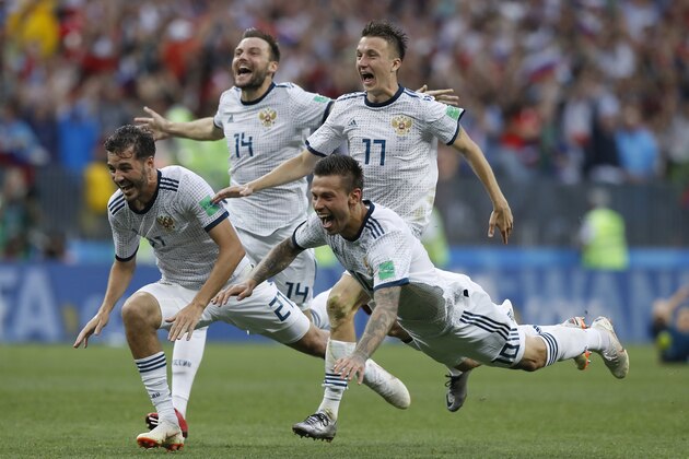 Russia's Fyodor Smolov, right, dives as he celebrates with teammates after Russia defeated Spain in a penalty shoot out during the round of 16 match between Spain and Russia at the 2018 soccer World Cup at the Luzhniki Stadium in Moscow, Russia, Sunday, July 1, 2018. (AP Photo/Manu Fernandez)
