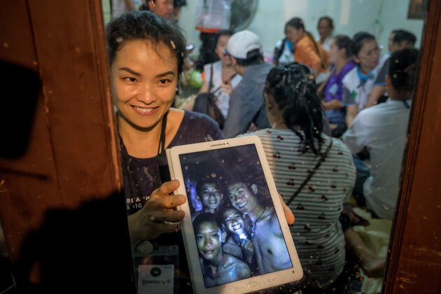 CHIANG RAI, THAILAND - JULY 2: Relatives of the missing boys show photos of them after the 12 boys and their soccer coach have been found alive in the cave where they've been missing for over a week after monsoon rains blocked the main entrance on July 02, 2018 in Chiang Rai, Thailand. Chiang Rai governor Narongsak Osatanakorn announced on Monday that the boys, aged 11 to 16, and their 25-year-old coach were being rescued from Tham Luang Nang Non cave after they were discovered by naval special forces and the challenge now will be to extract the party safely. (Photo by Linh Pham/Getty Images)