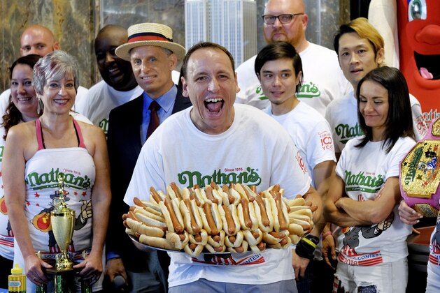 Ten-time and defending Nathan's Famous Men's Champion Joey Chestnut poses with 72 hot dogs during Nathan's Famous International Fourth of July Hot Dog Eating Contest weigh-in at the Empire State Building on Tuesday, July 3, 2018, in New York. (Photo by Evan Agostini/Invision/AP)