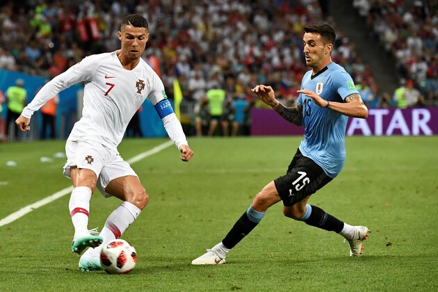 Portugal's forward Cristiano Ronaldo (L) vies with Uruguay's midfielder Matias Vecino during the Russia 2018 World Cup round of 16 football match between Uruguay and Portugal at the Fisht Stadium in Sochi on June 30, 2018. (Photo by Jonathan NACKSTRAND / AFP) / RESTRICTED TO EDITORIAL USE - NO MOBILE PUSH ALERTS/DOWNLOADS        (Photo credit should read JONATHAN NACKSTRAND/AFP/Getty Images)