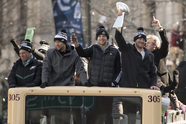 Philadelphia Eagles Carson Wentz, right, holds up the Vince Lombardi trophy as he rides with Nate Sudfeld, center right, Nick Foles, center left, and owner Jeffrey Lurie, left, during a Super Bowl victory parade, Thursday, Feb. 8, 2018, in Philadelphia. The Eagles beat the New England Patriots 41-33 in Super Bowl 52. (AP Photo/Christopher Szagola)
