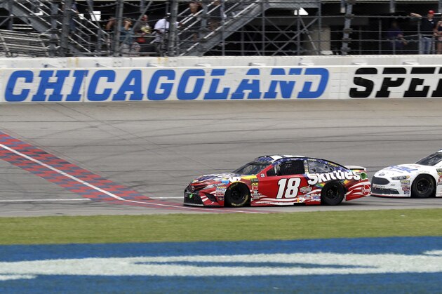 Kyle Busch (18) crosses the finish line to win a NASCAR Cup Series auto race at Chicagoland Speedway in Joliet, Ill., Sunday, July 1, 2018. (AP Photo/Nam Y. Huh)