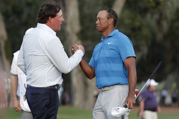 Phil Mickelson, left, shakes hands with Tiger Woods, after the first round of the Players Championship golf tournament, Thursday, May 10, 2018, in Ponte Vedra Beach, Fla. (AP Photo/Lynne Sladky)