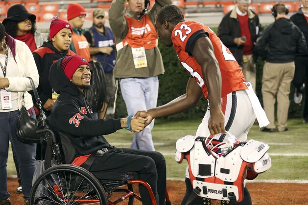 FILE - In this Nov. 21, 2015, file photo, injured Southern University receiver Devon Gales is greeted by Georgia wide receiver Shakenneth Williams (23) before an NCAA college football game between Georgia and Georgia Southern, in Athens, Ga. Gales, the Southern player who suffered a paralyzing neck injury in a game against Georgia, finally is headed home to Louisiana. (AP Photo/John Bazemore, File)