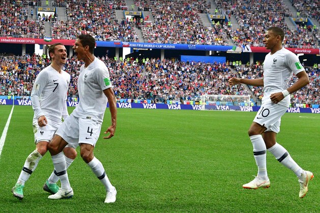TOPSHOT - France's defender Raphael Varane (C) celebrates with France's forward Antoine Griezmann (L) and France's forward Kylian Mbappe after scoring the opener during the Russia 2018 World Cup quarter-final football match between Uruguay and France at the Nizhny Novgorod Stadium in Nizhny Novgorod on July 6, 2018. (Photo by Mladen ANTONOV / AFP)        (Photo credit should read MLADEN ANTONOV/AFP/Getty Images)