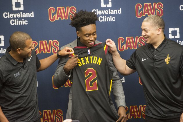 Cleveland Cavaliers first round draft selection, Collin Sexton, center, looks over his jersey with Cleveland Cavaliers general manager Koby Altman, left and Cavaliers head coach Tyronn Lue during a news conference at the Cavaliers training facility in Independence, Ohio, Friday, June 22, 2018. Sexton was the eighth selection of the draft. (AP Photo/Phil Long)