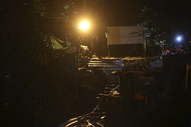 A rescuer makes his way at the entrance to a cave complex where 12 boys and their soccer coach went missing, in Mae Sai, Chiang Rai province, in northern Thailand, Wednesday, July 4, 2018. With heavy rains forecast to worsen flooding in a cave in northern Thailand where 12 boys and their soccer coach are waiting to be extracted by rescuers, authorities say they might be forced to have them swim out through a narrow, underwater passage. The 13 are described as healthy and being looked after by medics inside the cave.(AP Photo/Sakchai Lalit)