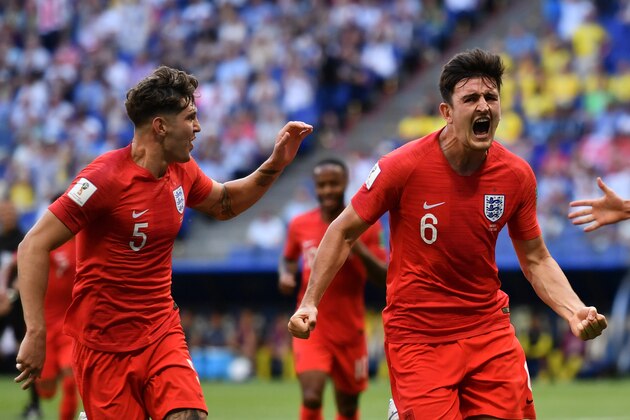 England's defender Harry Maguire (R) celebrates past England's defender John Stones after scoring the opener during the Russia 2018 World Cup quarter-final football match between Sweden and England at the Samara Arena in Samara on July 7, 2018. (Photo by Fabrice COFFRINI / AFP) / RESTRICTED TO EDITORIAL USE - NO MOBILE PUSH ALERTS/DOWNLOADS        (Photo credit should read FABRICE COFFRINI/AFP/Getty Images)
