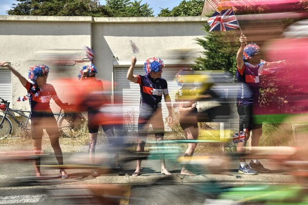 TOPSHOT - British fans wave Union Jack flags during the first stage of the 105th edition of the Tour de France cycling race between Noirmoutier-en-l'ile and Fontenay-le Comte, western France, on July 7, 2018. (Photo by Marco BERTORELLO / AFP)        (Photo credit should read MARCO BERTORELLO/AFP/Getty Images)